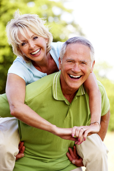 Older Couple Piggy Back Ride Laughing