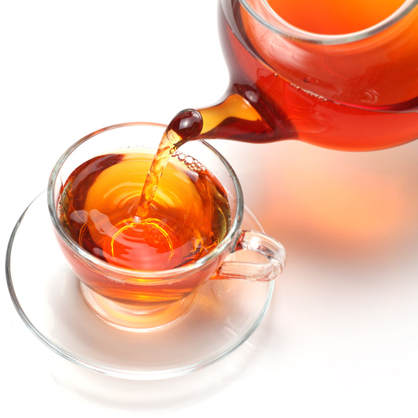 Glass Teapot Pouring Oolong Tea into Glass Teacup