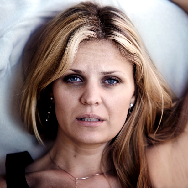 Woman Laying in Bed with Bags Under Her Eyes