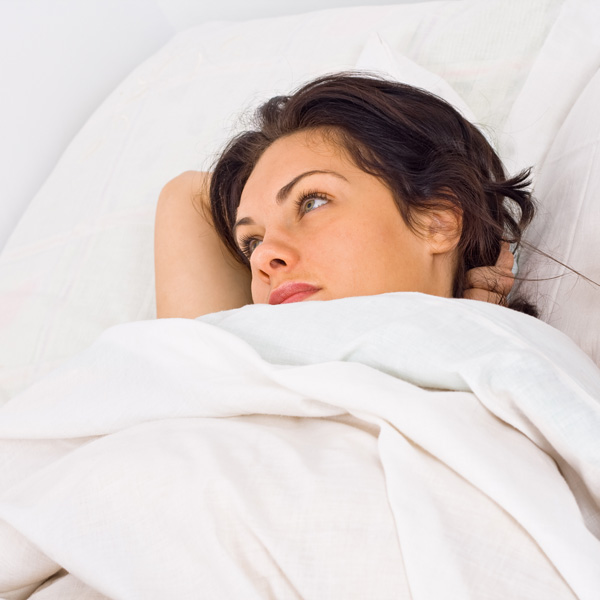 Woman Waking up in the Morning in White Sheets